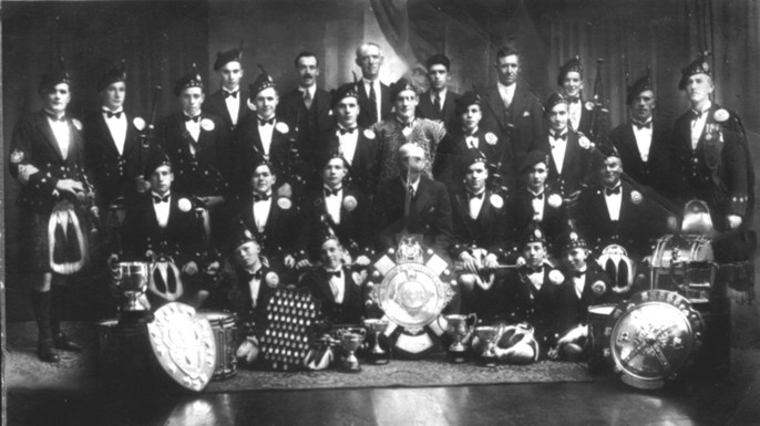 Formal indoor photo of the band with trophies